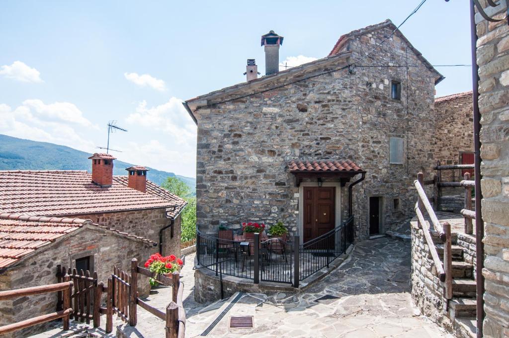 - un ancien bâtiment en pierre avec un portail et une terrasse dans l'établissement Country House Vezzano, à Chiusi della Verna