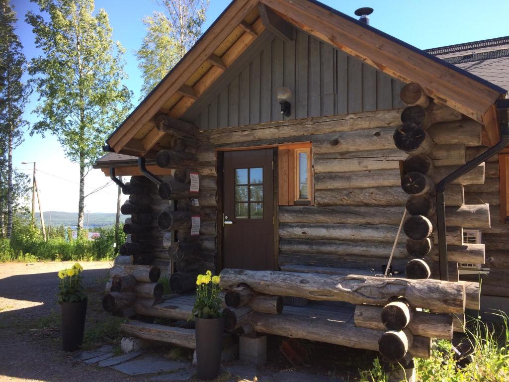 Cabaña de madera con porche y puerta en Kelotulkku Lodge, en Muurame