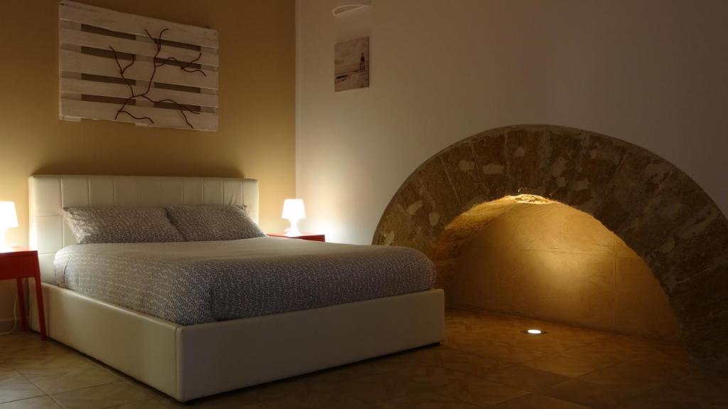 パレルモにあるLa casa sul mercato anticoのベッドルーム1室(ベッド1台、ランプ2つ付)