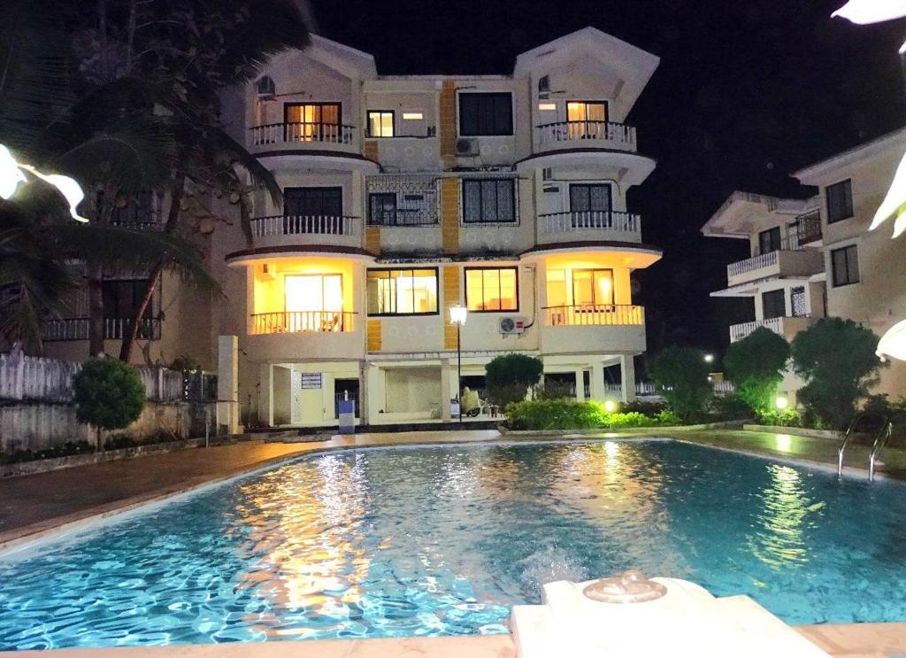 a building with a swimming pool in front of a building at Casale Majorda in Majorda