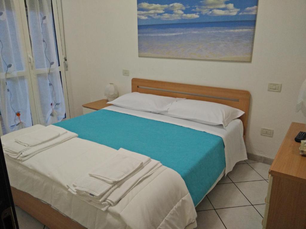マリーナ・ディ・マッサにあるIl Castelluccio residenceのベッドルーム1室(青い毛布付きのベッド1台付)