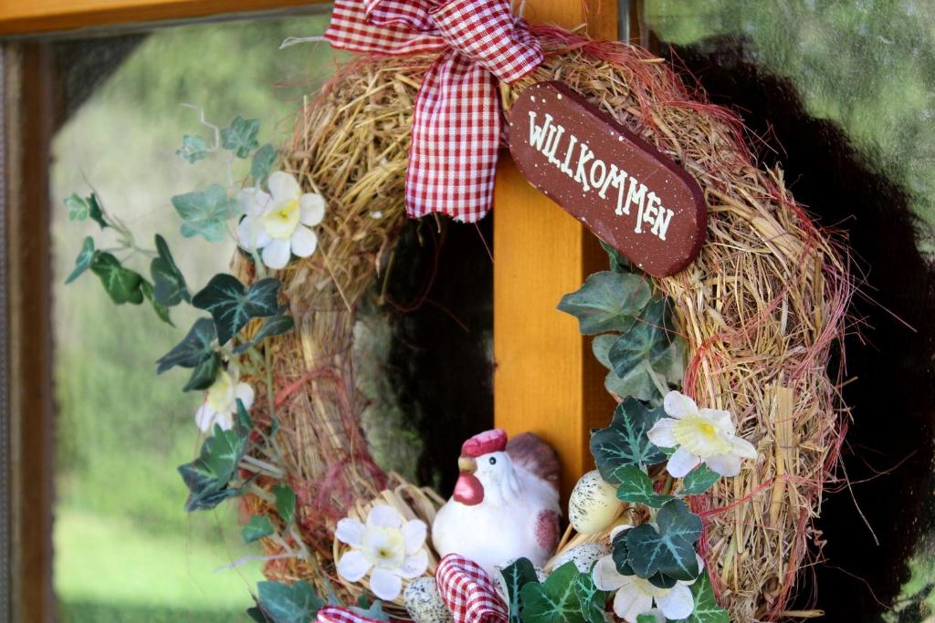 a wreath with a chicken and flowers on a door at Ferienwohnung Hausladen in Arnbruck