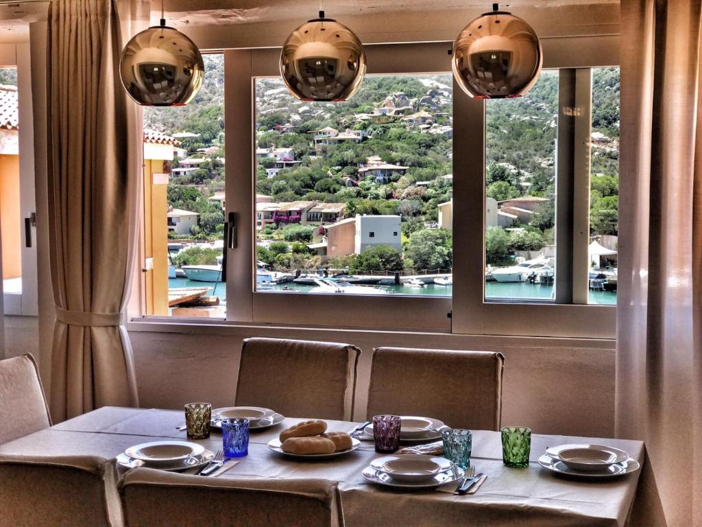 a table in a restaurant with a large window at Appartamento Il Principe in Porto Cervo
