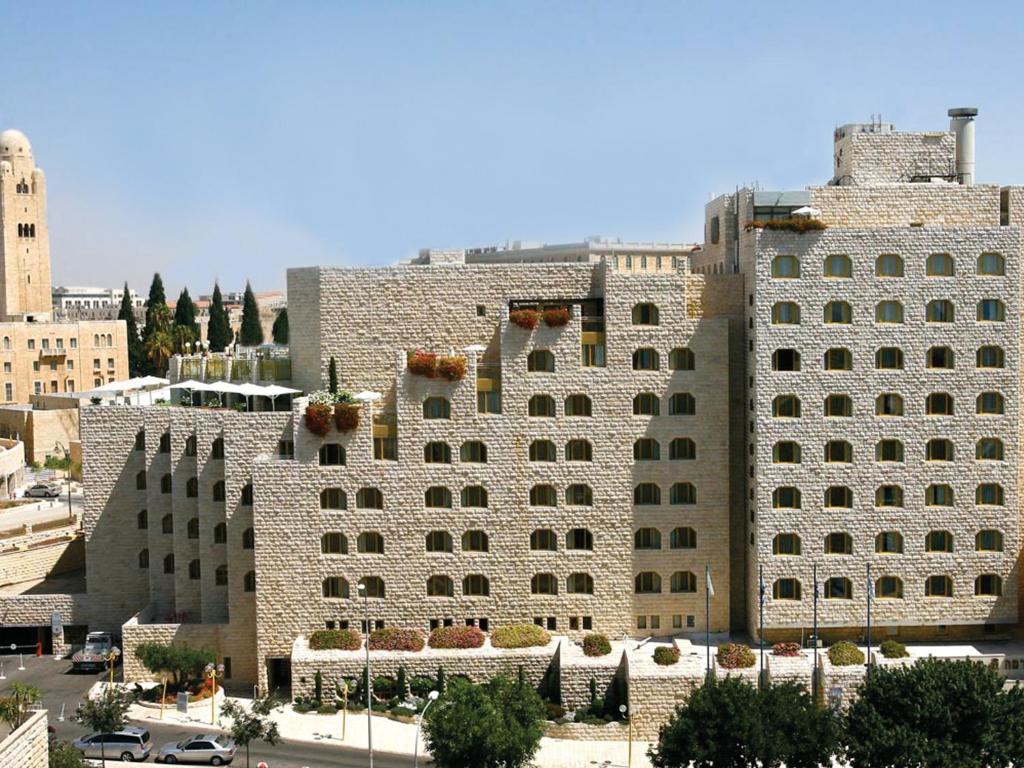 um grande edifício de pedra com plantas sobre ele em Dan Panorama Jerusalem Hotel em Jerusalém