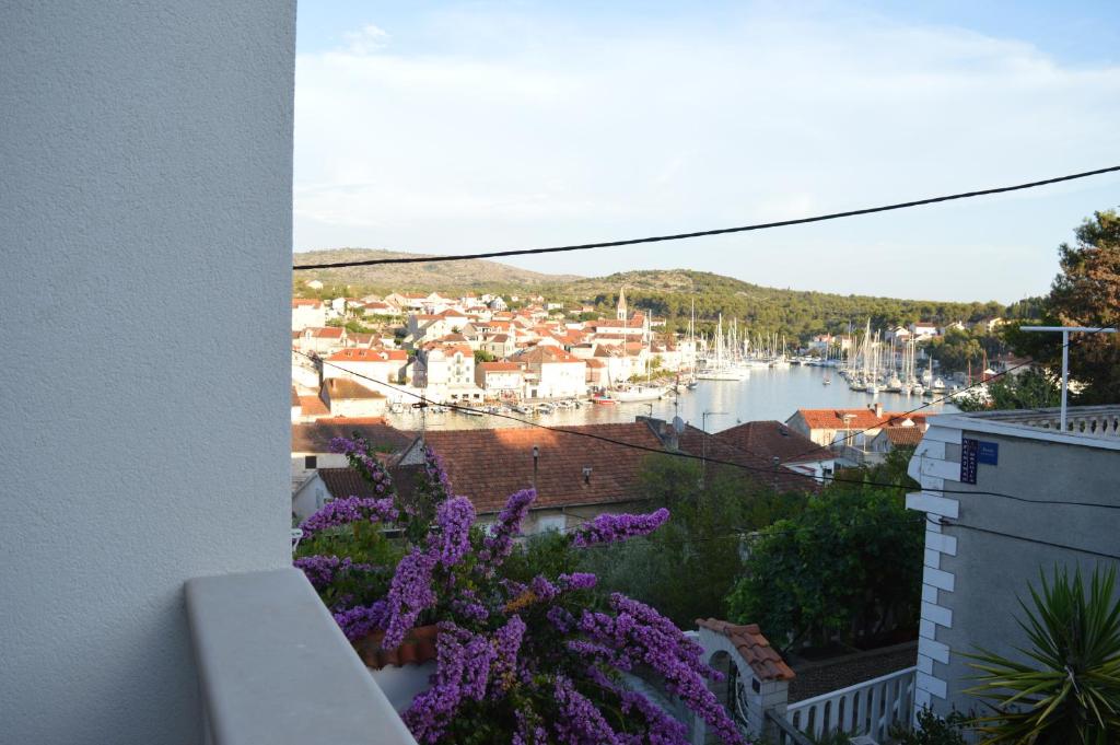 a view of a harbor from a balcony with purple flowers at Galicija apartment in Milna
