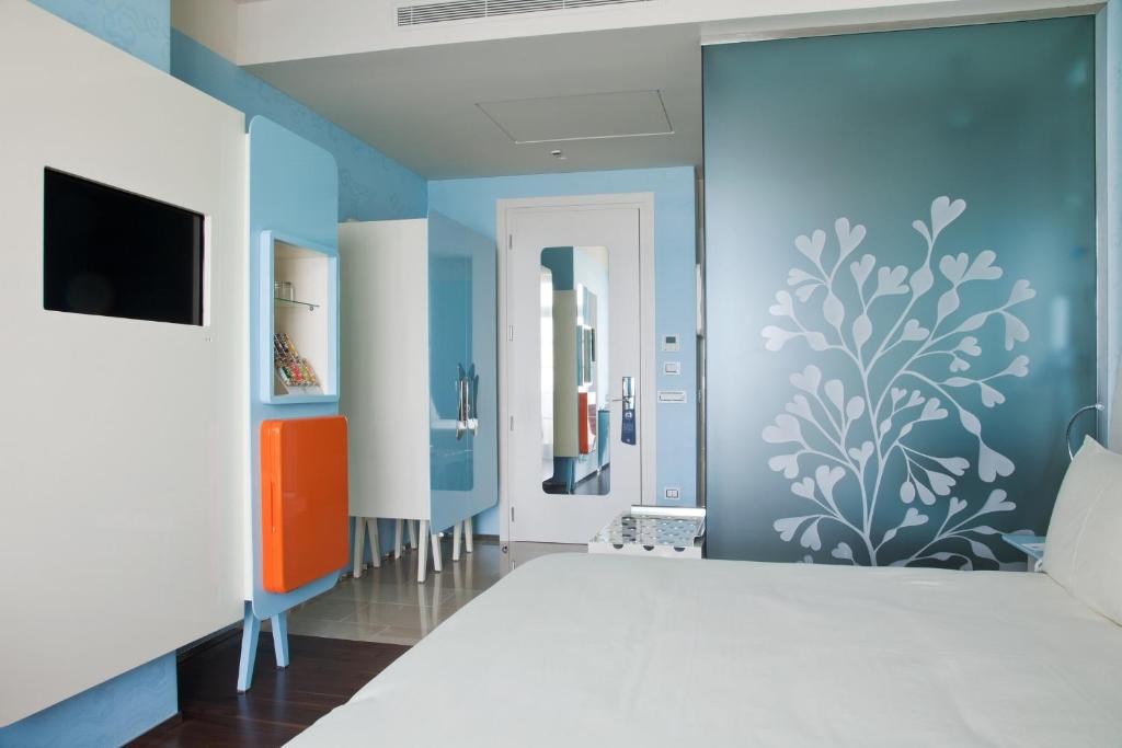 a living room with blue walls and a tv at JR Hotels Bari Grande Albergo delle Nazioni in Bari
