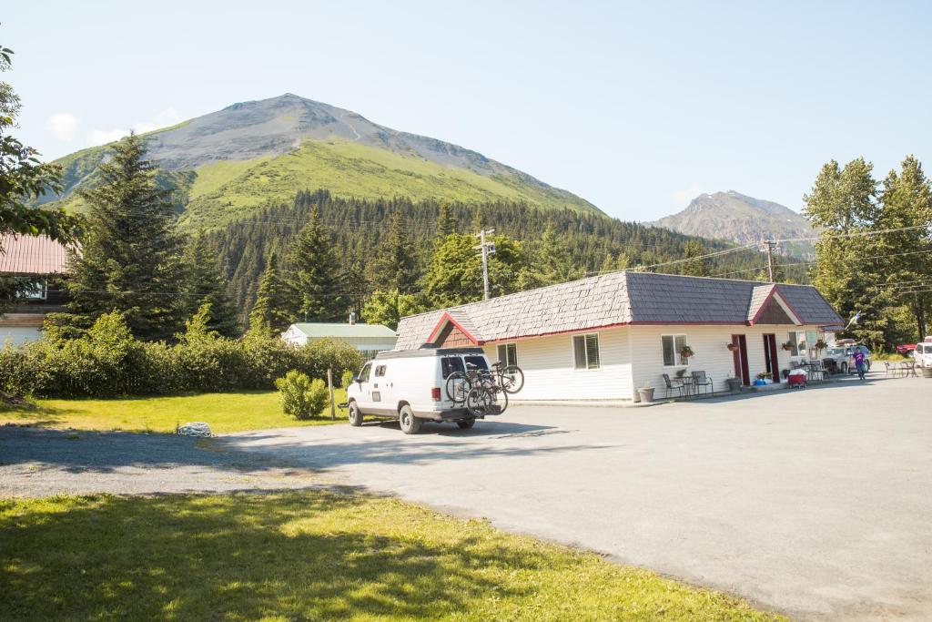 una furgoneta blanca estacionada frente a un edificio con una montaña en Trailhead Lodging, en Seward