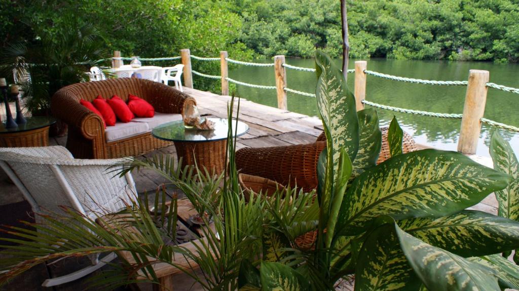 un patio con sillas de mimbre, una mesa y algunas plantas en Casa Escollera, en Santa Marta