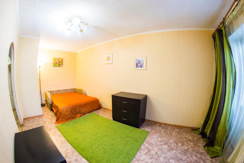 オムスクにあるRENT-сервис Apartment On Marksa 31のベッドルーム1室(ベッド1台、緑のラグ付)