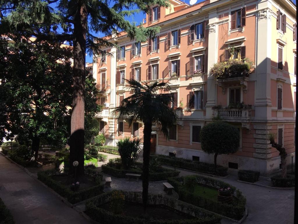 un grande edificio con una palma di fronte di The Roman Way San Giovanni a Roma