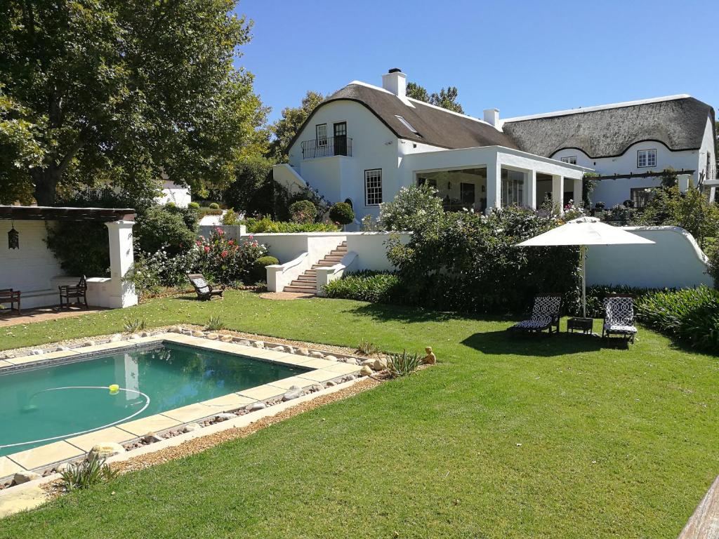 a house with a swimming pool in the yard at Gemoedsrus Farm in Stellenbosch