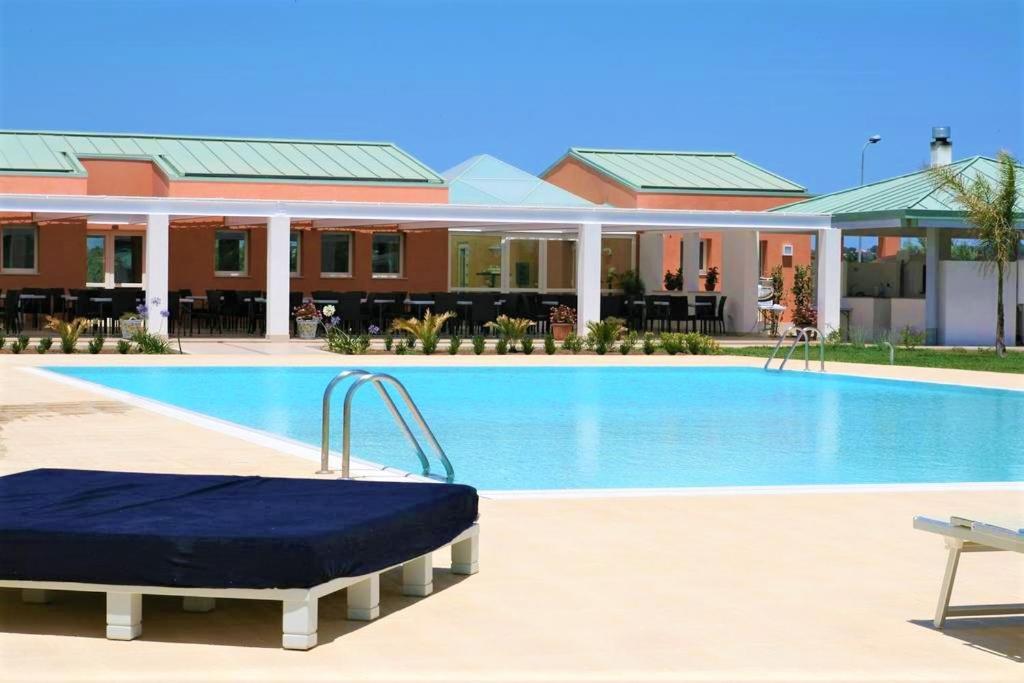 einen Pool mit einer Matratze vor einem Hotel in der Unterkunft Hotel Villa Fanusa in Syrakus