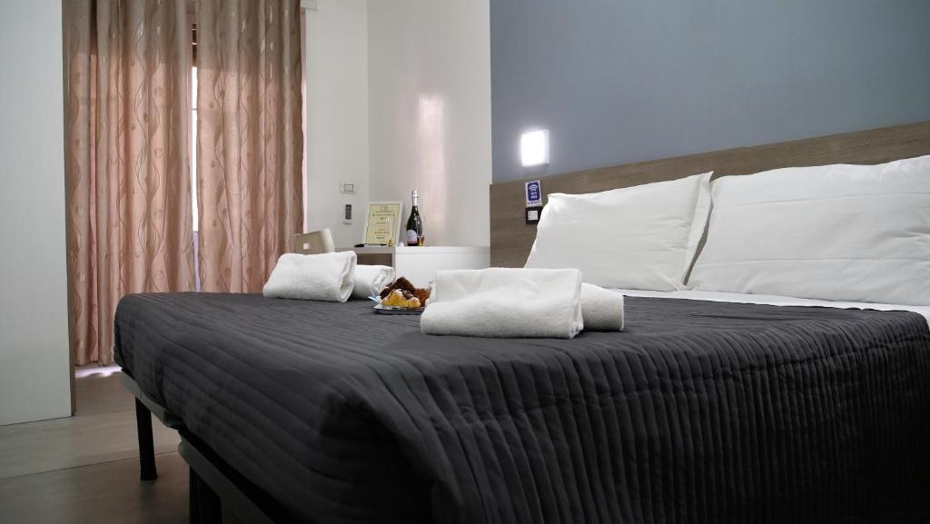 sypialnia z dużym łóżkiem z 2 poduszkami w obiekcie Tiburtina Royal Suites w Rzymie
