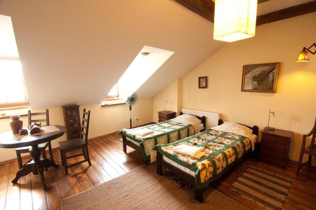 a bedroom with two beds and a table and a window at Lublin Apartaments in Lublin