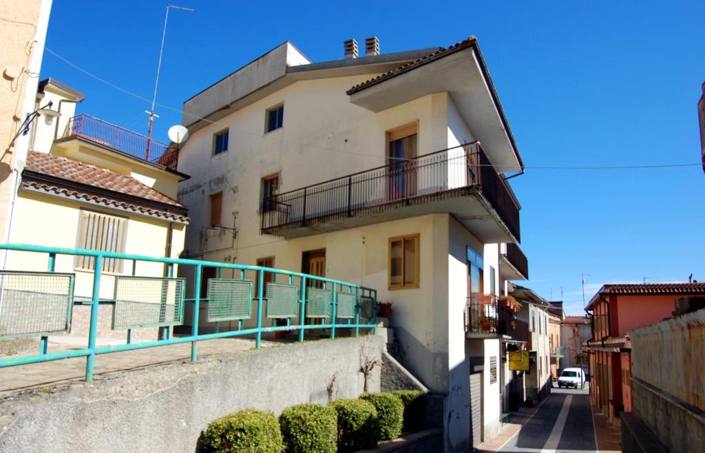 a white building with a balcony on a street at Casa Vacanze del Pollino in Fardella