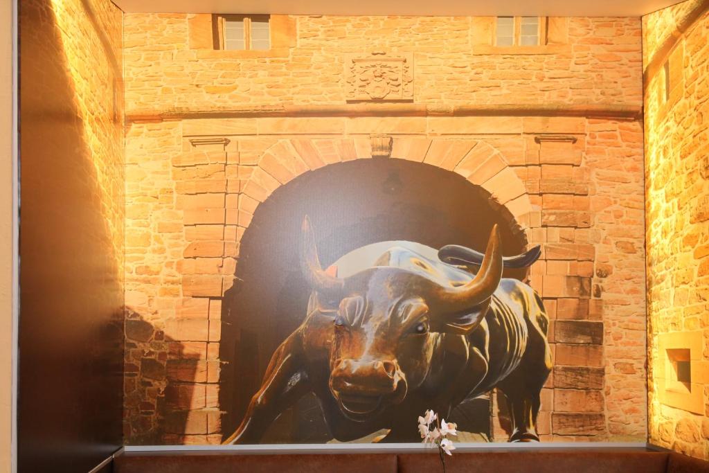 uma estátua de um touro numa parede de tijolos em Hotel Steakhouse Am Rathaus em Tann