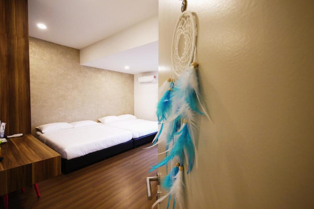 Pokój z łóżkiem i drzwiami z niebieskimi piórami w obiekcie DreamCatchers Home w mieście Kuantan