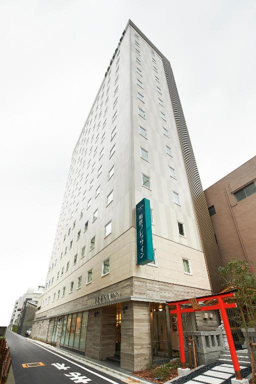 a tall white building with a sign on it at Sotetsu Fresa Inn Tokyo Kinshicho in Tokyo
