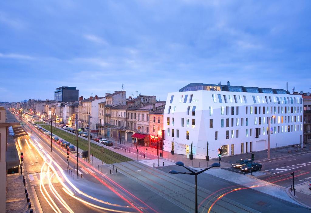 a city street with buildings and cars on the road at Seeko'o Hotel Bordeaux in Bordeaux