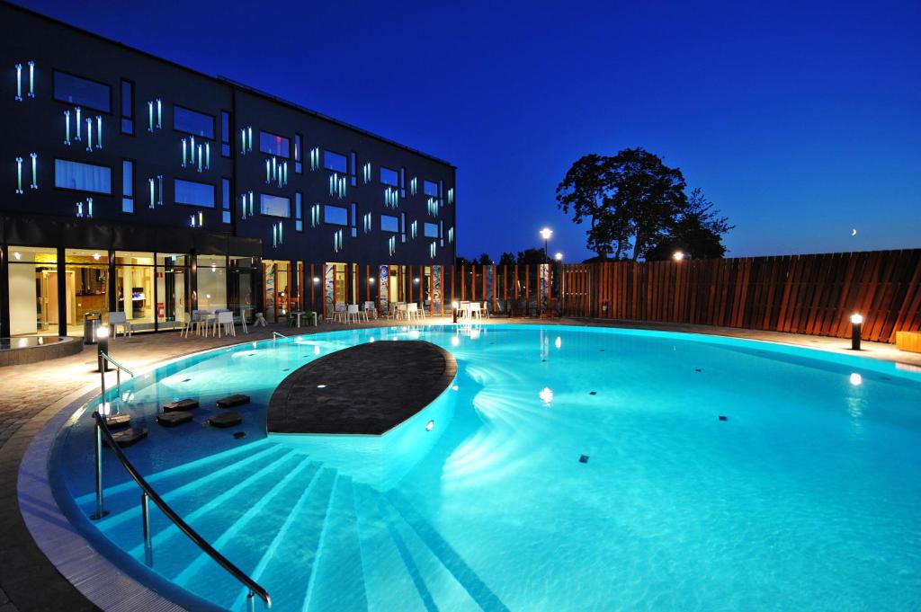 una grande piscina di fronte a un edificio di notte di Kosta Boda Art Hotel a Kosta