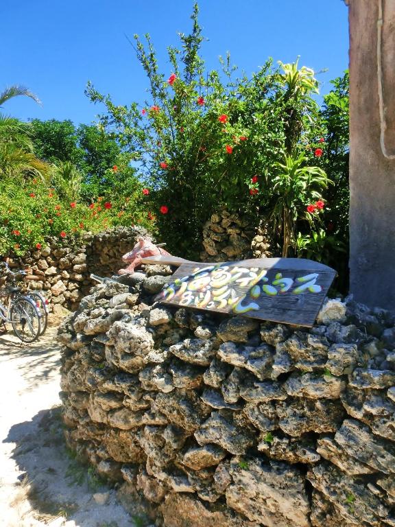 a bench sitting on top of a stone wall at Taketomijima Guesthouse and je Taime in Taketomi