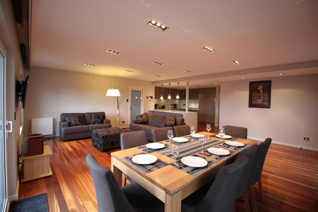 a dining room table with chairs and a living room at Sunny 3 Bedroom Apartment in Sandy Bay in Sandy Bay
