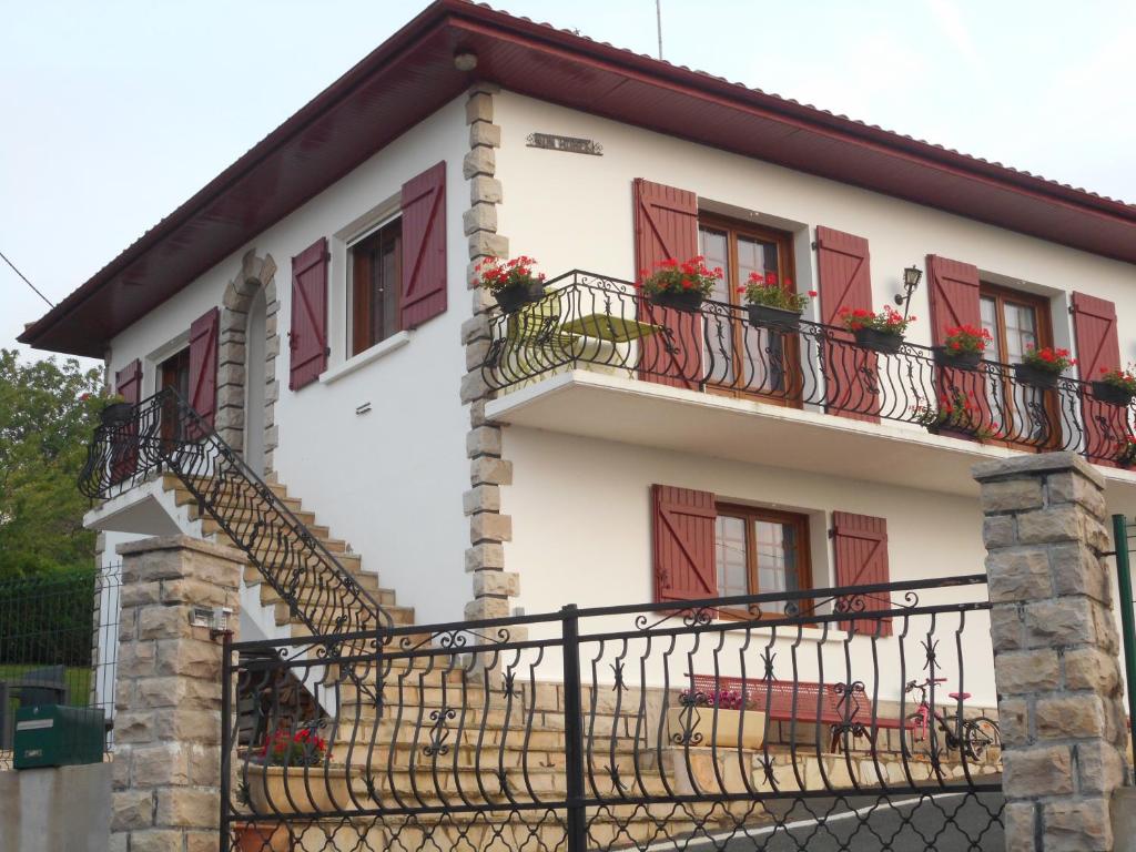 Cette maison blanche dispose de volets rouges et de balcons. dans l'établissement Nun Hobeki, à Aincille