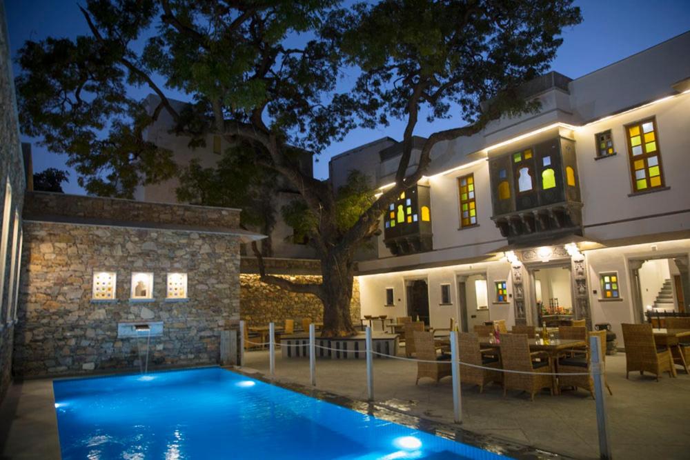 uma piscina em frente a um edifício à noite em The Neem Tree em Udaipur