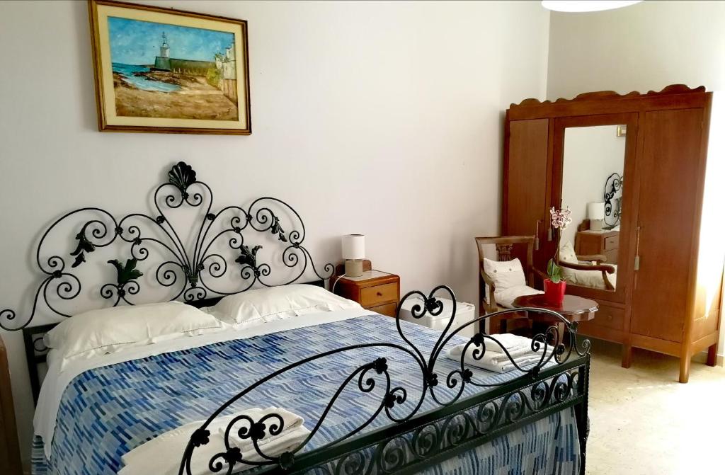 a bedroom with a black and white bed and a mirror at B&B Faro Bianco in Otranto