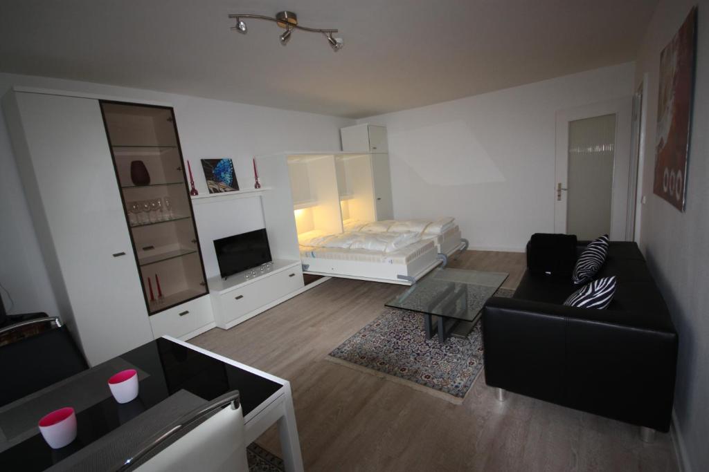 ein Wohnzimmer mit Sofa und Bett in der Unterkunft Ferienwohnung Wattkieker in Husum