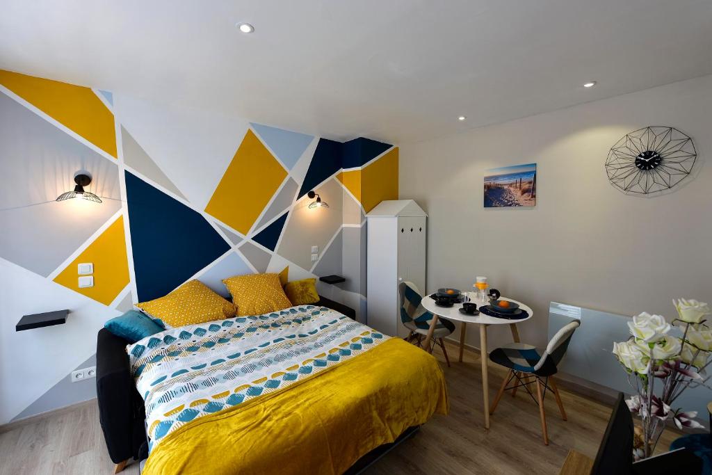 a bedroom with a bed and a table with chairs at Opal'évasion - RDC- Cocon pour 2 pers - 250m de la mer in Berck-sur-Mer