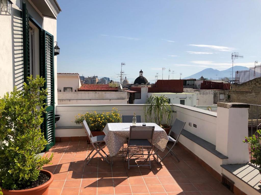 a patio with a table and chairs on a balcony at Gregorius Diamerisma panoramic terrace in Naples