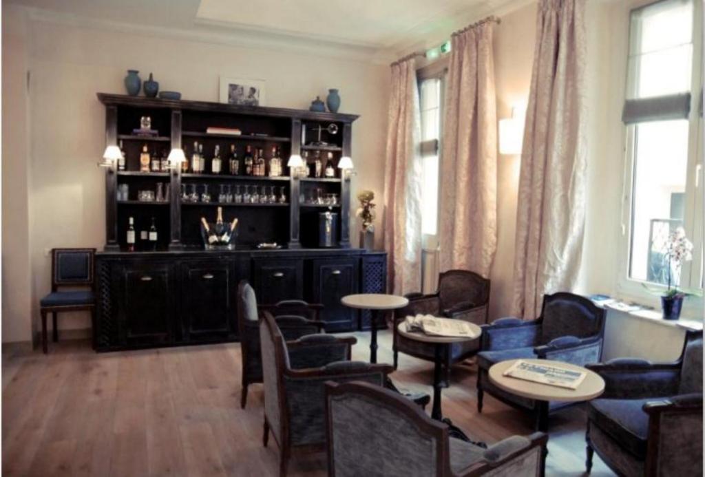 a living room with a bar with chairs and tables at Magda Champs Elysées in Paris