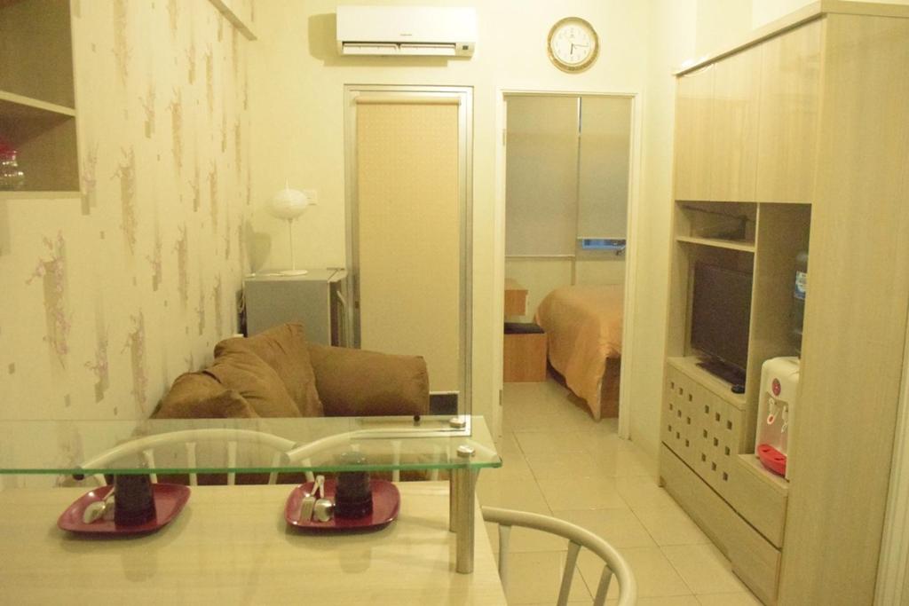 a living room with a couch and a glass table at Pakubuwono Terrace Apartment in Jakarta