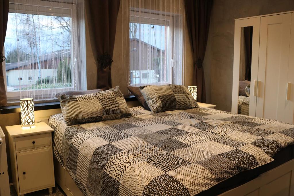 een slaapkamer met een geruit bed en 2 ramen bij Gestüt Kaiserhof in Legelshurst