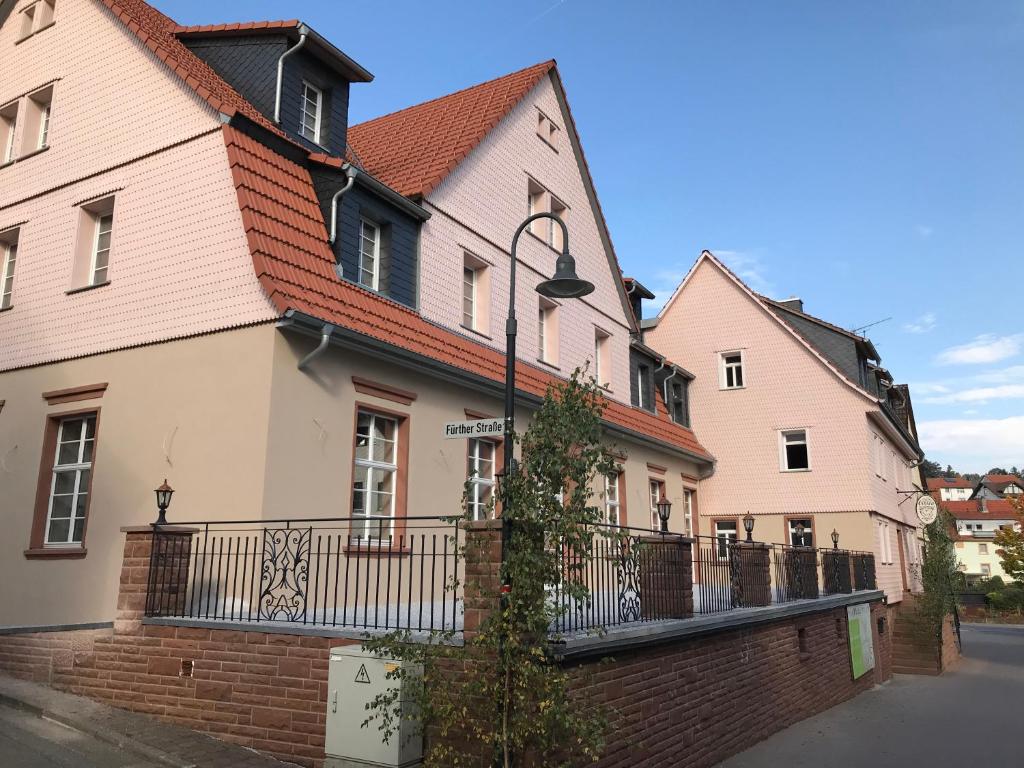 a row of pink and white houses on a street at Gasthof zum Ochsen in Hammelbach