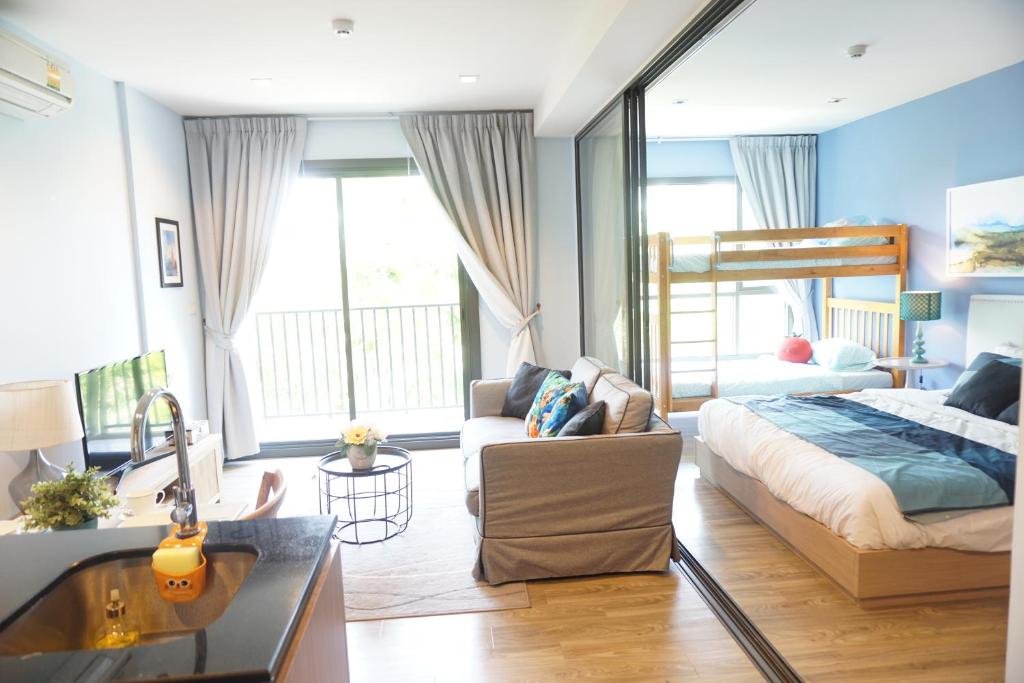 1 dormitorio con cama, sofá y lavamanos en Rain Condo Hua Hin - Cha Am by SN, en Cha Am