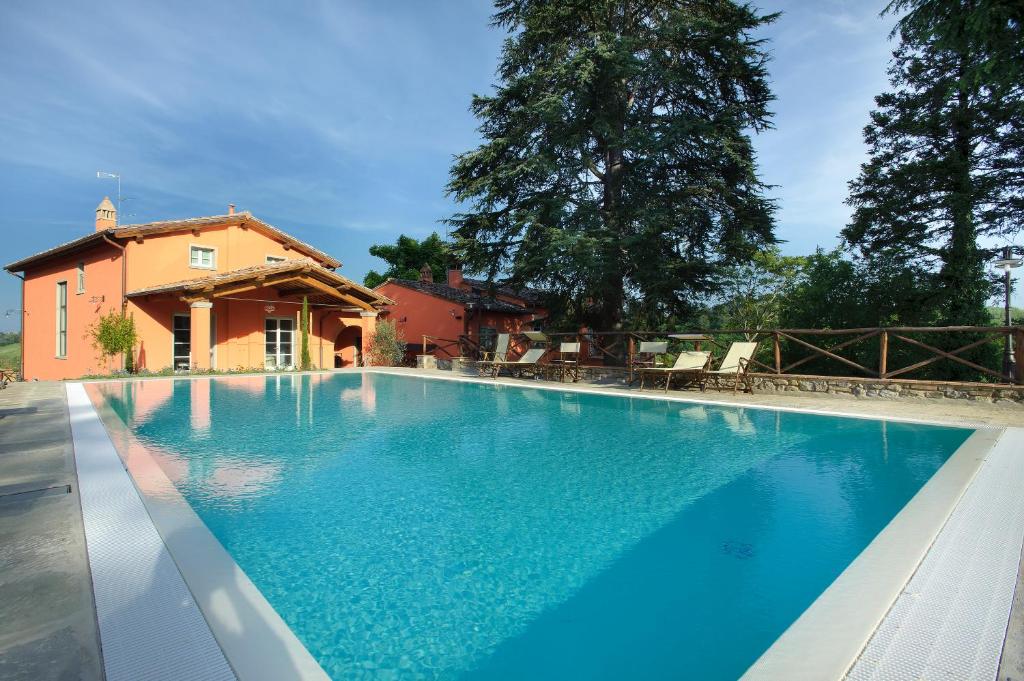 une grande piscine en face d'une maison dans l'établissement Agriturismo Villa Le Vigne, à Montevarchi