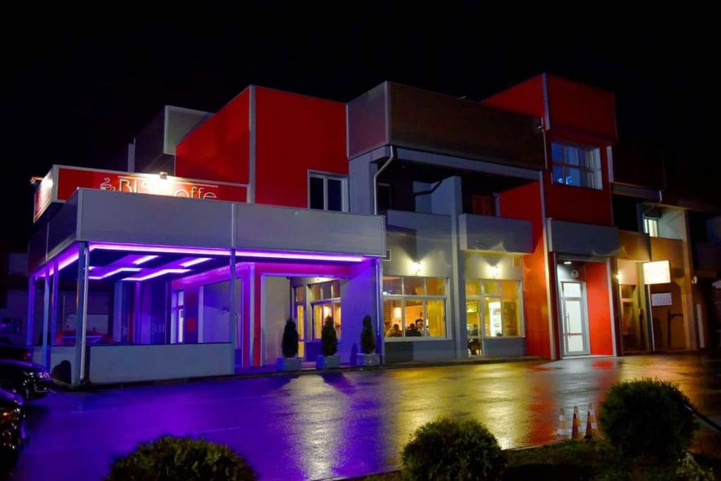 budynek z fioletowymi światłami przed nim w nocy w obiekcie Prenoćište Bis w mieście Prijepolje