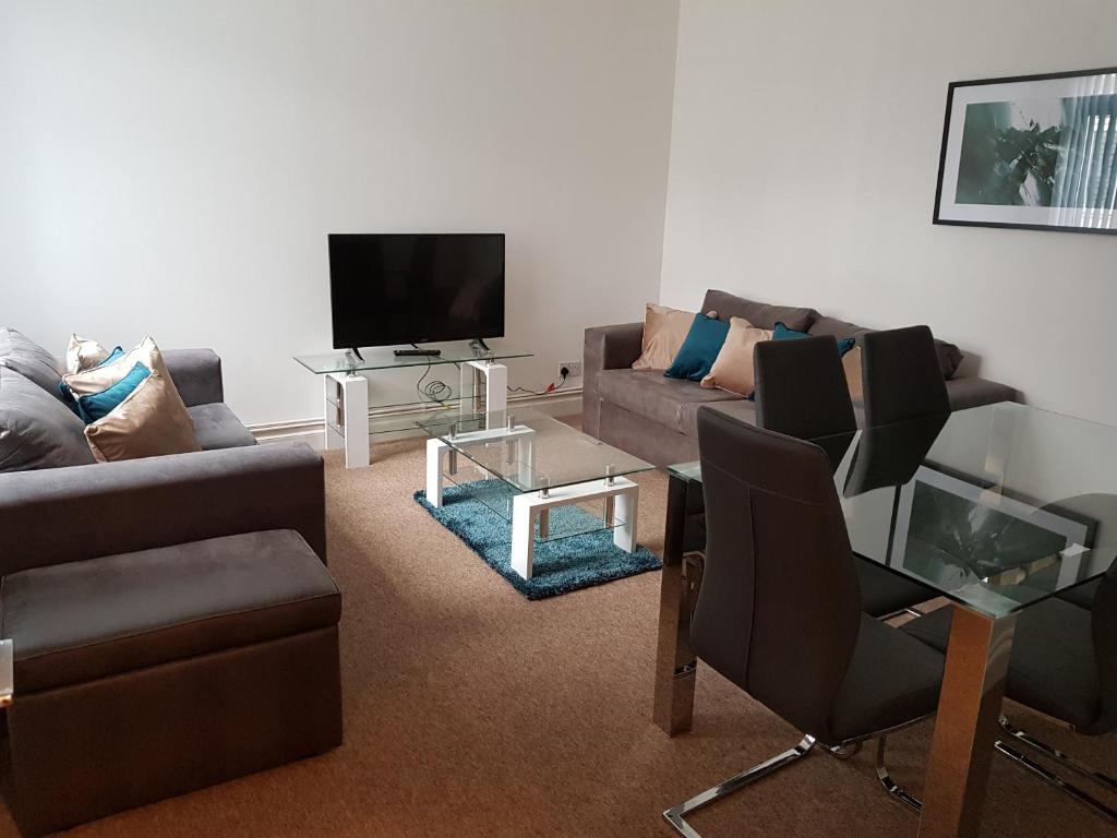 uma sala de estar com um sofá e uma televisão em Norfolk House em Southampton