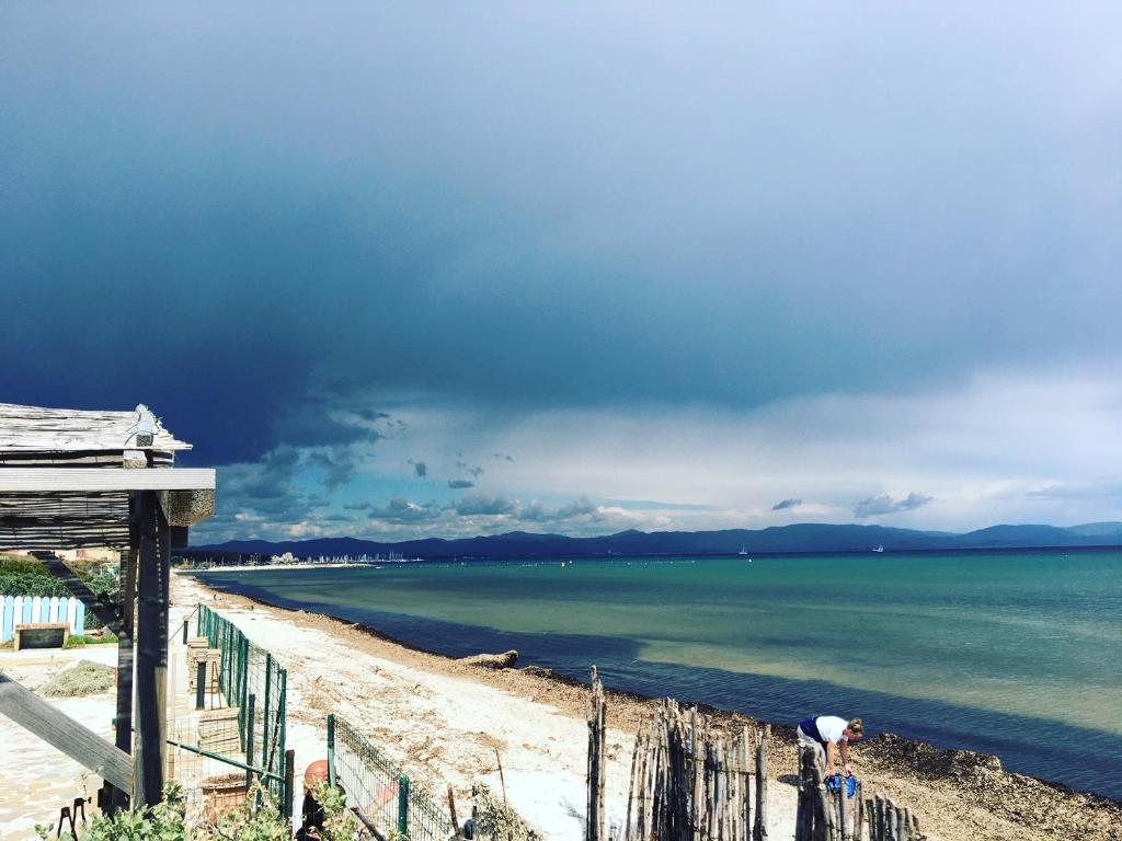 une personne debout sur une plage près de l'eau dans l'établissement Le Club des Cigales, à Hyères