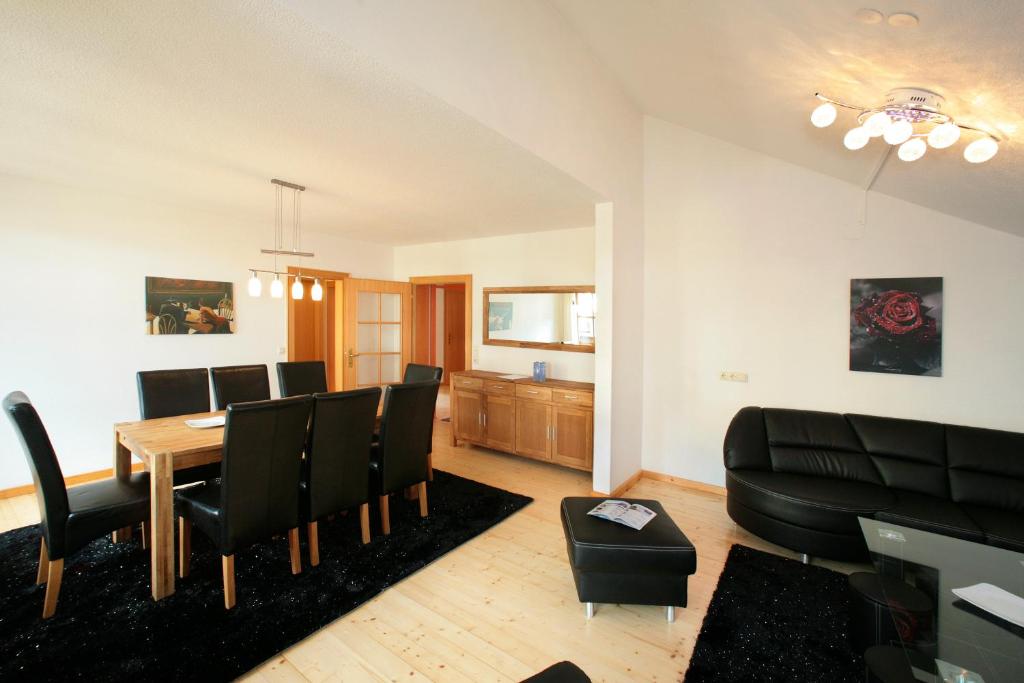 salon ze stołem jadalnym i krzesłami w obiekcie City Apartments Mozart w mieście Zell am See