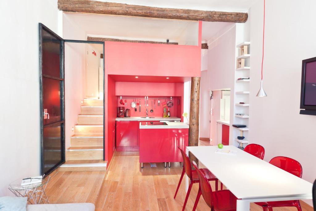 カンヌにあるFestival Apartmentのキッチン(赤いキャビネット、テーブル、椅子付)
