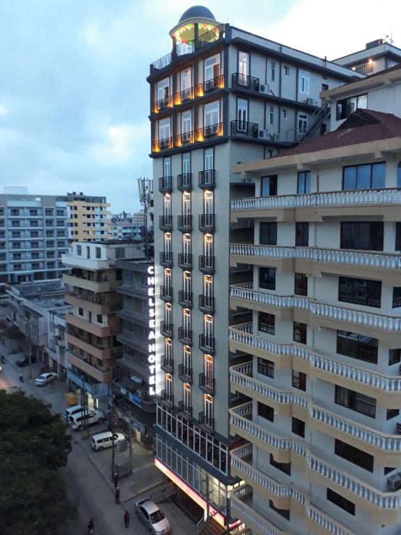 een groot wit gebouw met een klok erop bij Chelsea Hotel in Dar es Salaam