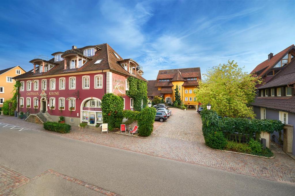 un groupe de bâtiments avec des voitures garées devant eux dans l'établissement Landhotel Krone, à Heitersheim