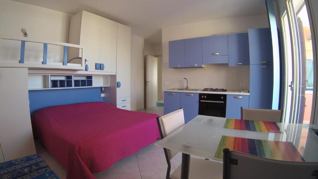 eine Küche mit blauen Schränken und einem Tisch mit einer roten Decke in der Unterkunft Athena b&b Castro in Castro di Lecce