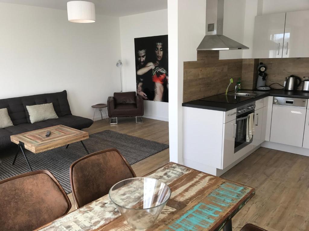 cocina y sala de estar con sofá y mesa en Ferien Apartment en Bremen