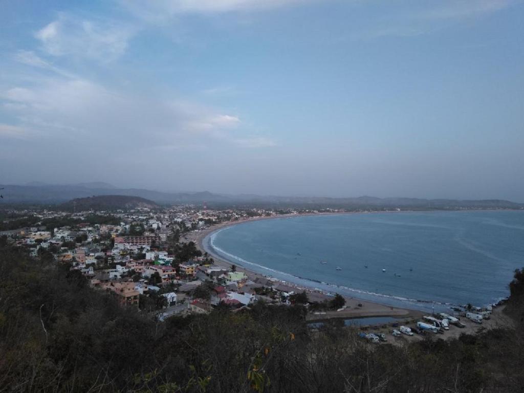 een uitzicht op een strand met een stad en de oceaan bij Hotel & Suites VAYOR in San Patricio Melaque