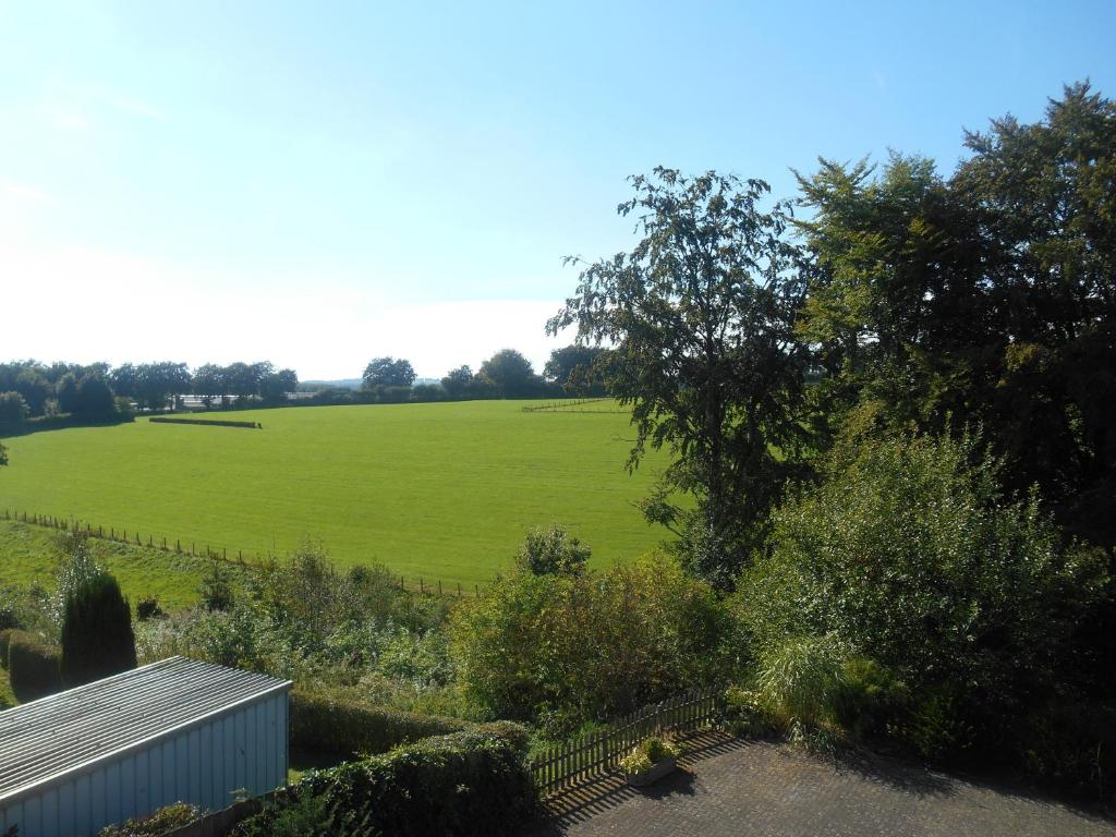 ein großes, grünes Gras mit einem Zaun in der Unterkunft B&B Haus Jola in Nidrum