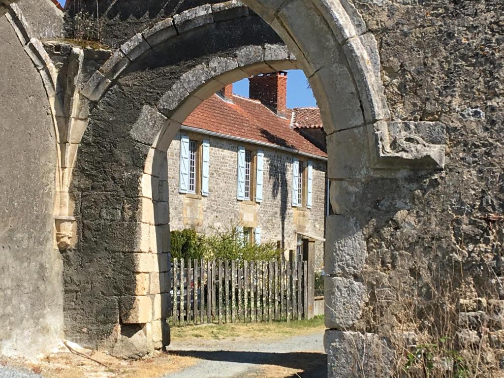 um arco no lado de um edifício com uma cerca em Le Vieux Château de Saint Martin-Lars em Saint-Martin-Lars-en-Sainte-Hermine
